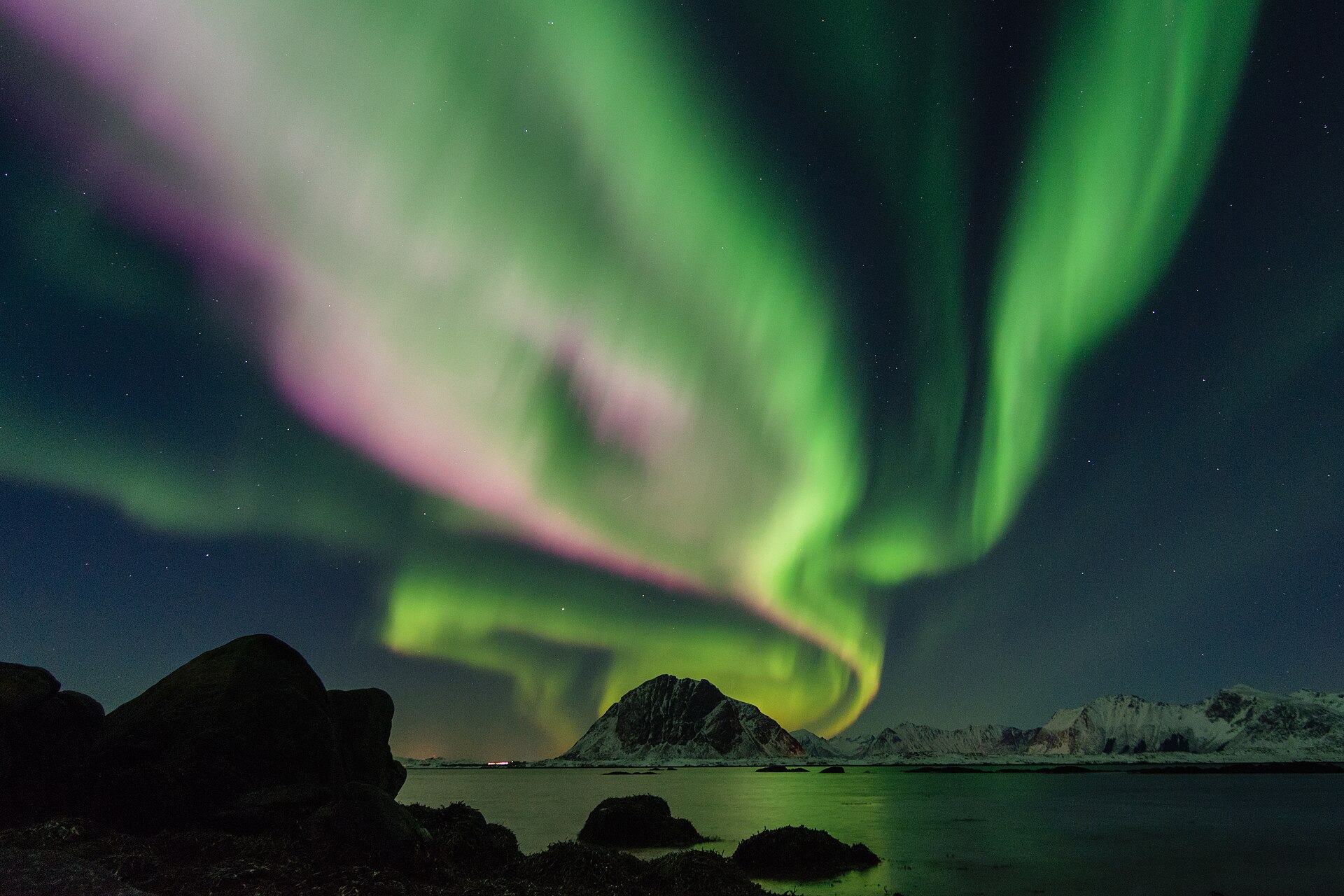 Aurora curtains over a mountain coast