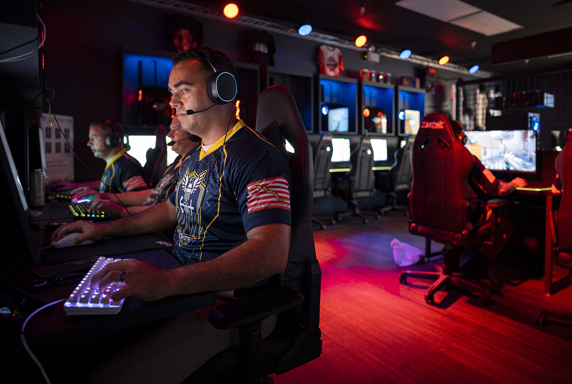 Gamer at a glowing keyboard, hand on the mouse