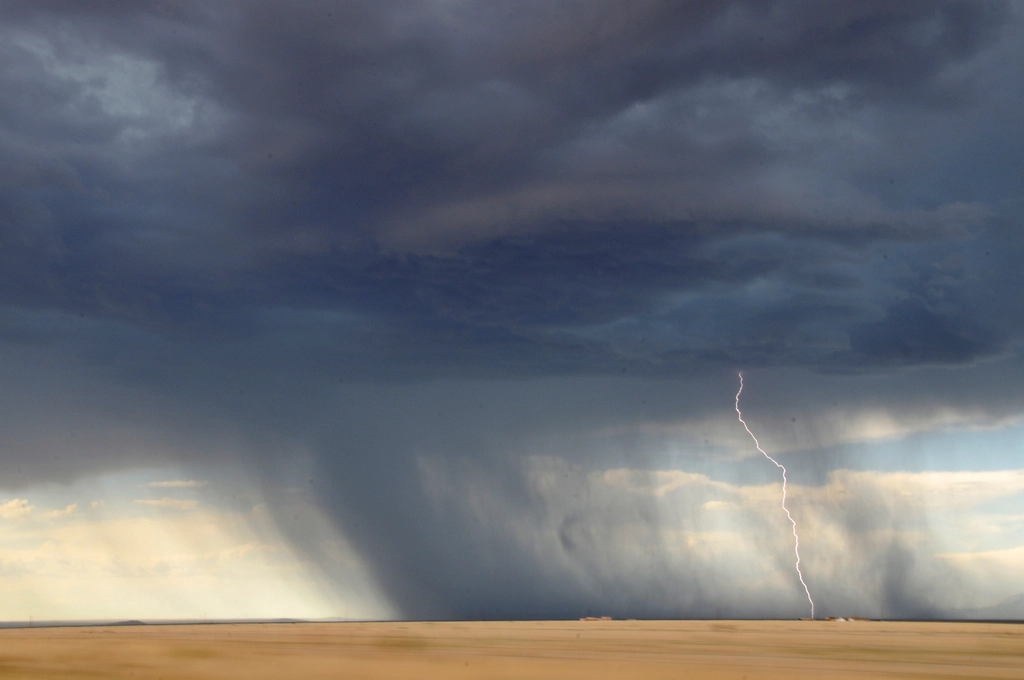 Lightning striking from a storm cell over open plains