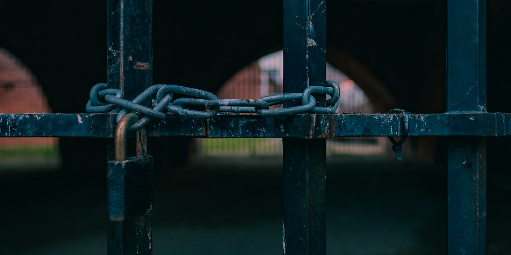 A gate chained shut with a padlock