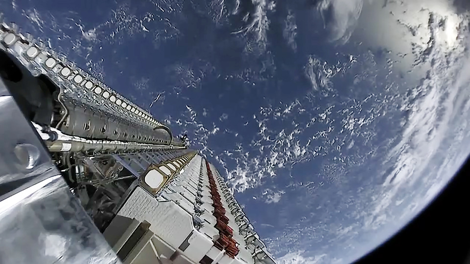 A stack of satellites moments before deployment over Earth