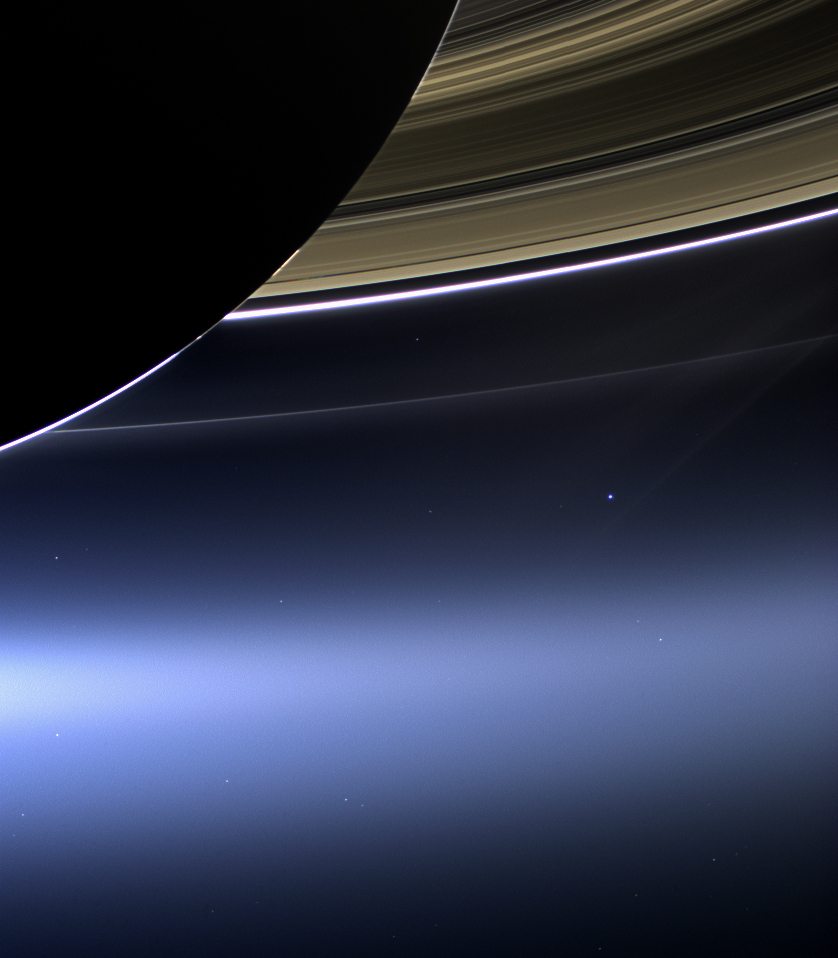 Earth, a single point of light beneath Saturn's rings