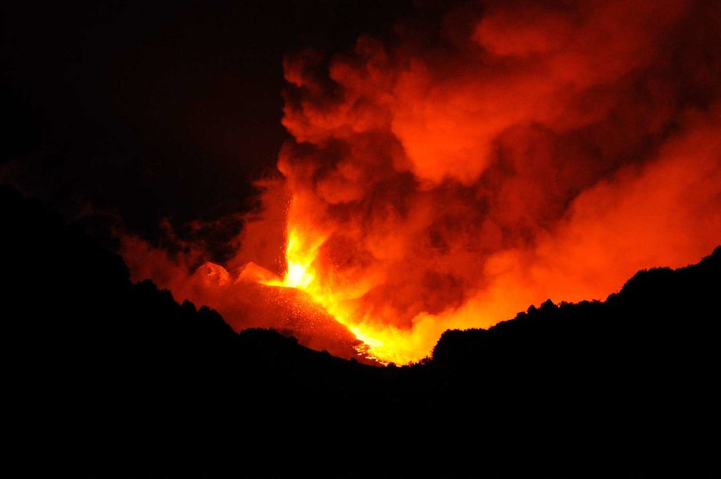 A volcano erupting at night